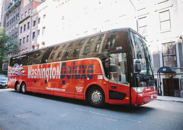 A red Washington Deluxe coach on a Washington street